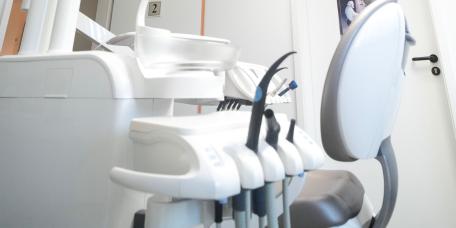 Moderner Behandlungsraum mit Zahnarztstuhl und Deckenbild.