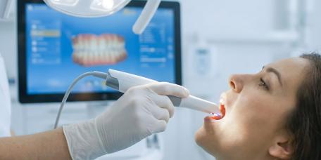 Zahnarzt scannt Zähne einer Patientin digital im Behandlungsraum.